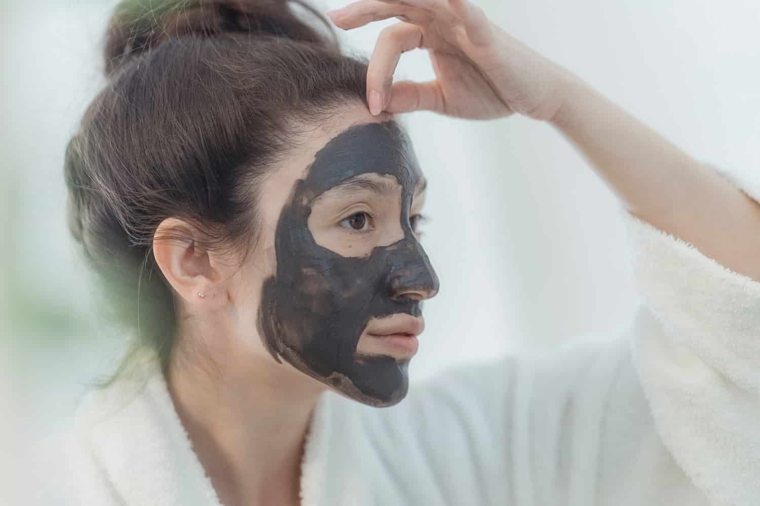Can You Get Glowing Skin Overnight Naturally? 3 woman using a dark colored facemask to get glowing skin