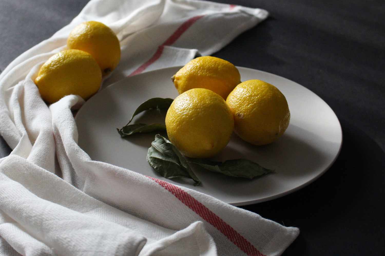 Best Natural Skin Exfoliants + DIY Recipes 5 lemons arranged on a white plate