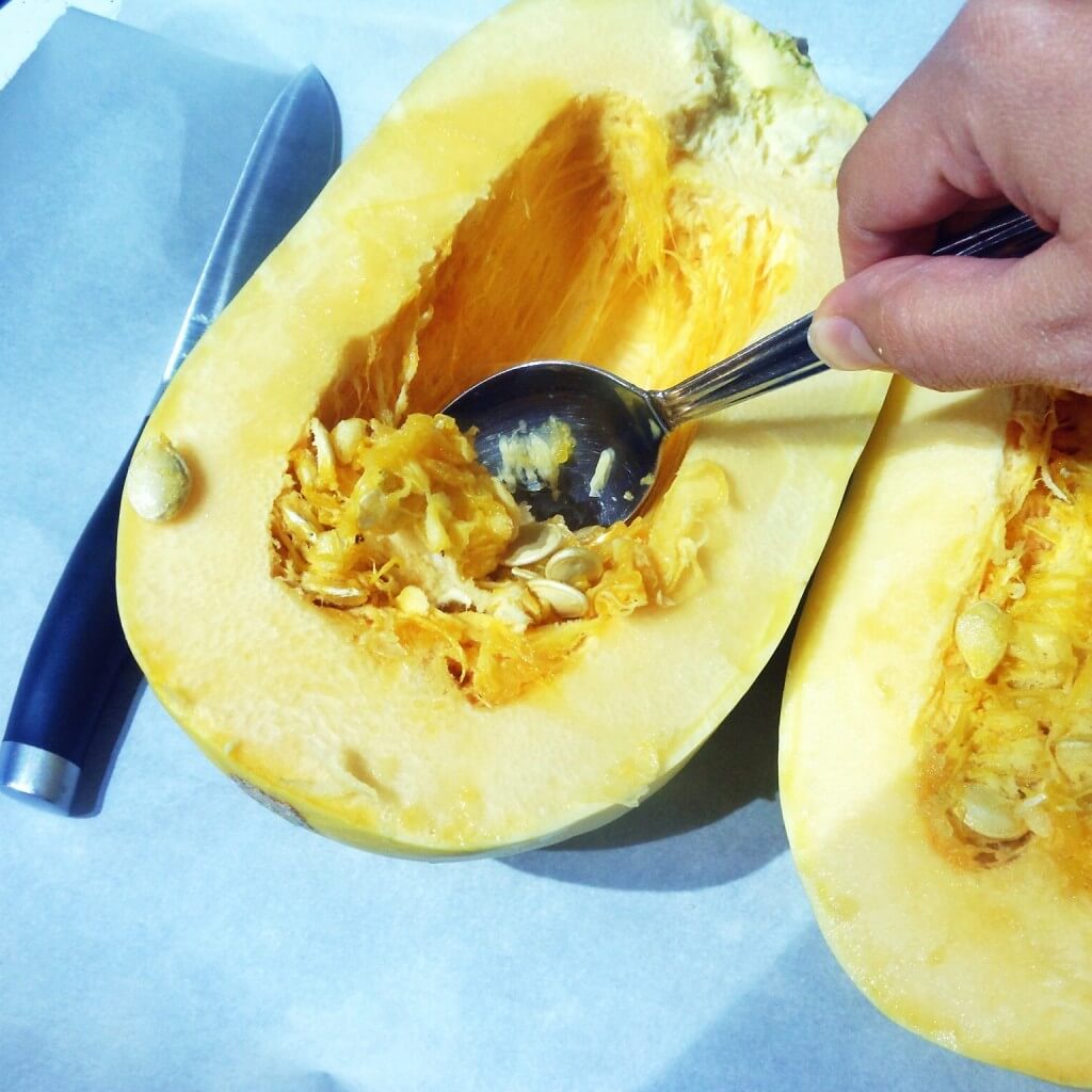 How to Cook Spaghetti Squash 4 spoon scraping the seeds from inside a spaghetti squash