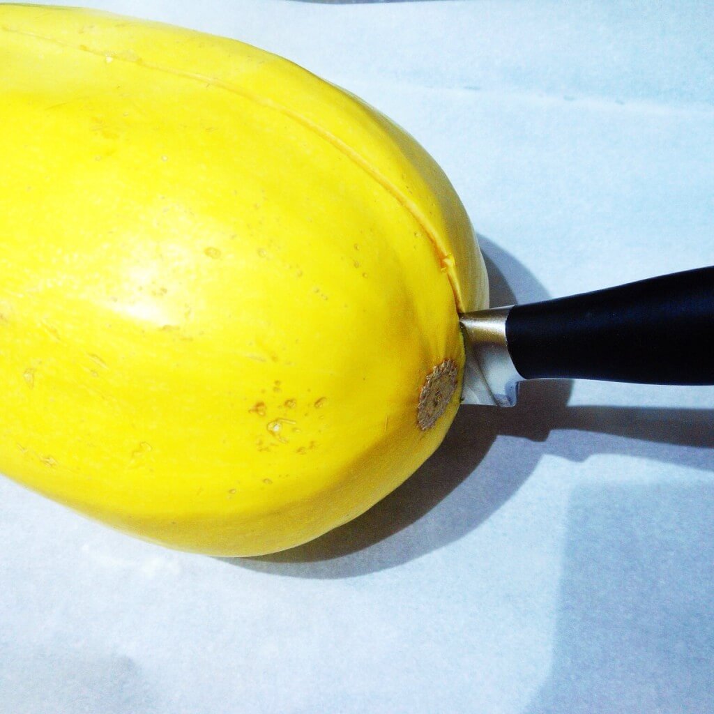 How to Cook Spaghetti Squash 3 knife cutting into partially cooked spaghetti squash