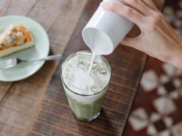 Paleo milk being poured in iced matcha latte coffee substitute