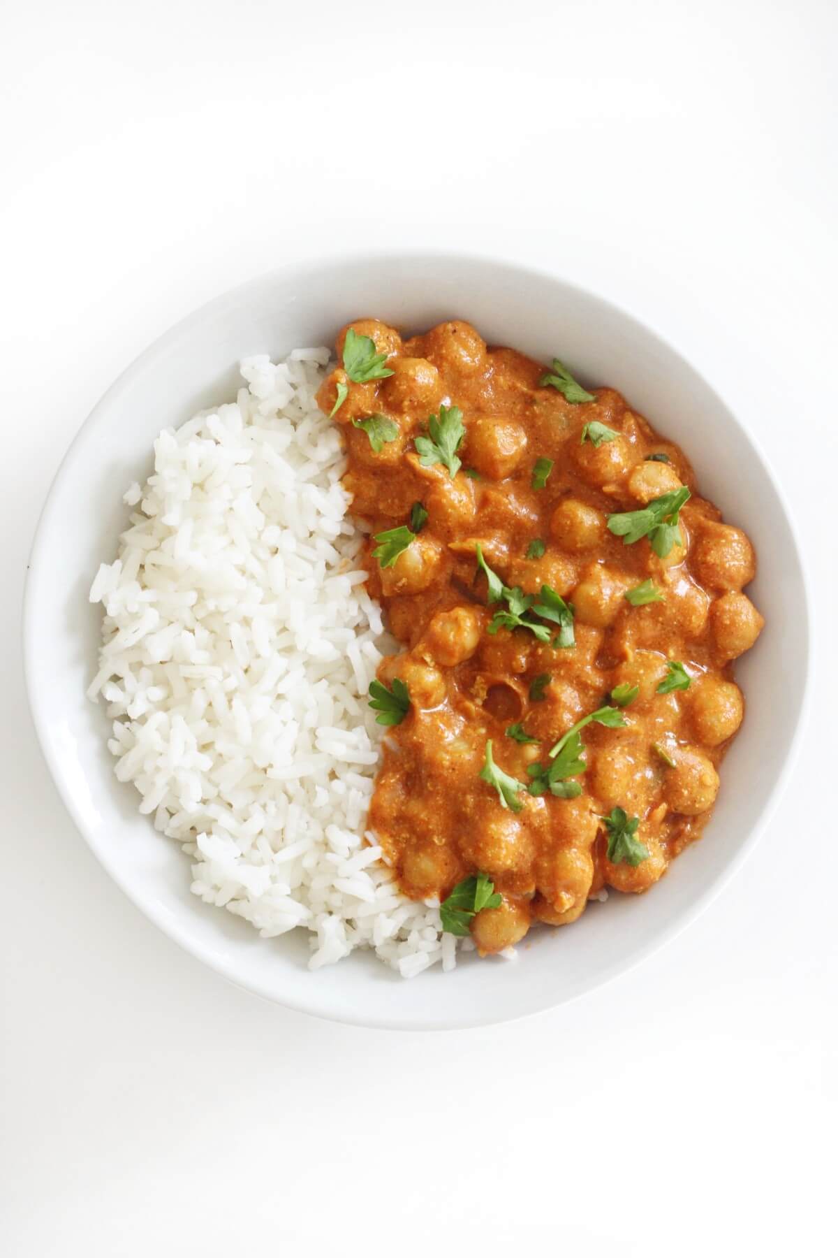 Don't Miss These Recipes Using Coconut Yogurt 11 A bowl is half filled with jasmine rice and half with butter chickpeas with coconut yogurt